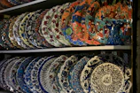 Elegant ceramic plates with traditional Ottoman patterns displayed on a wooden shelf.