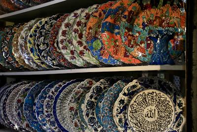 Elegant ceramic plates with traditional Ottoman patterns displayed on a wooden shelf.