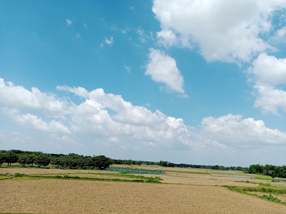 A panoramic view of a vast farm under clear blue skies.