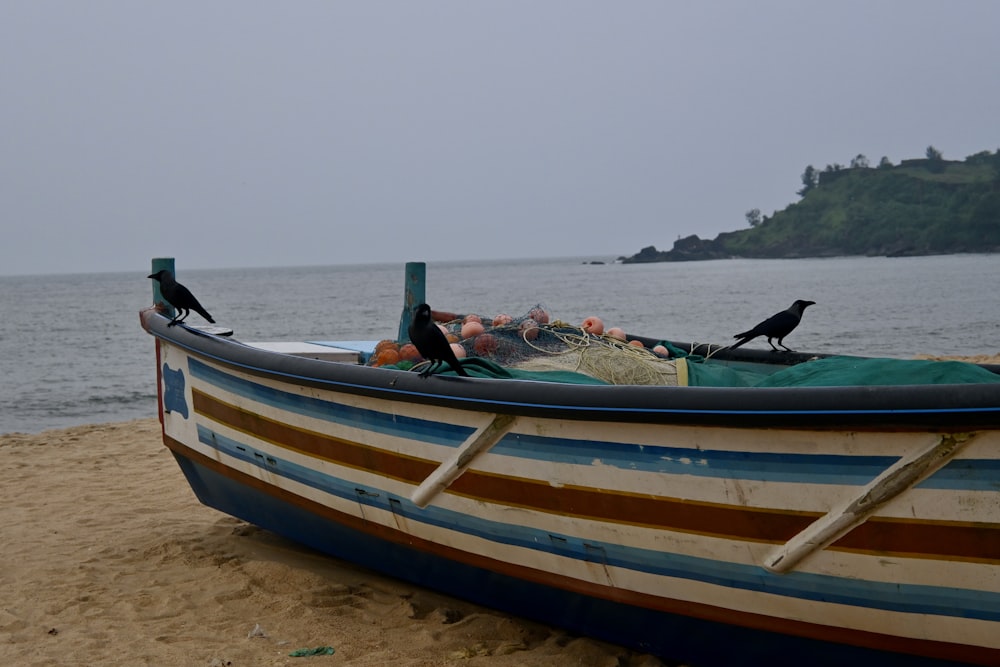 a boat sitting on top of a sandy beach