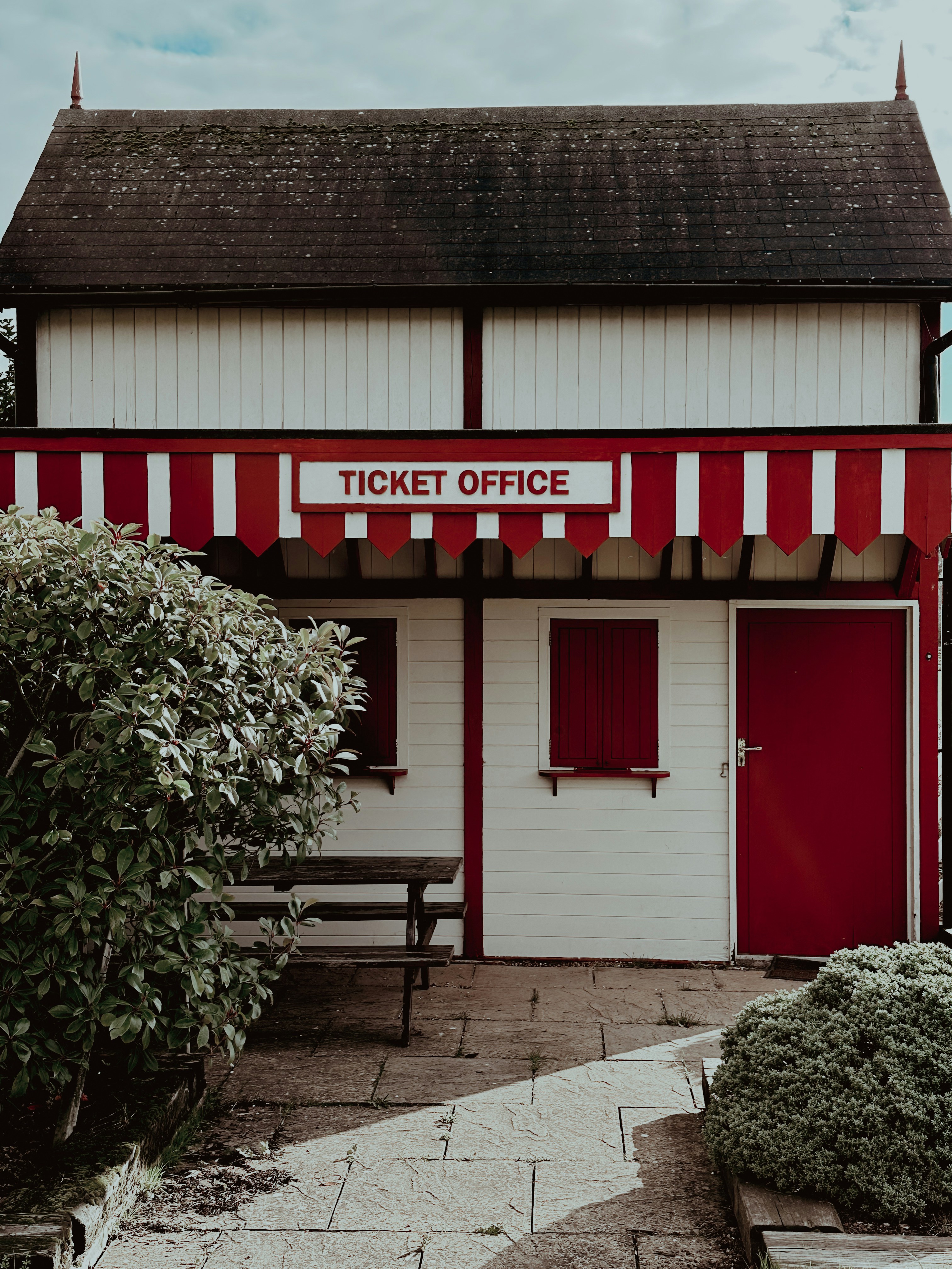 a red and white building with a ticket office
