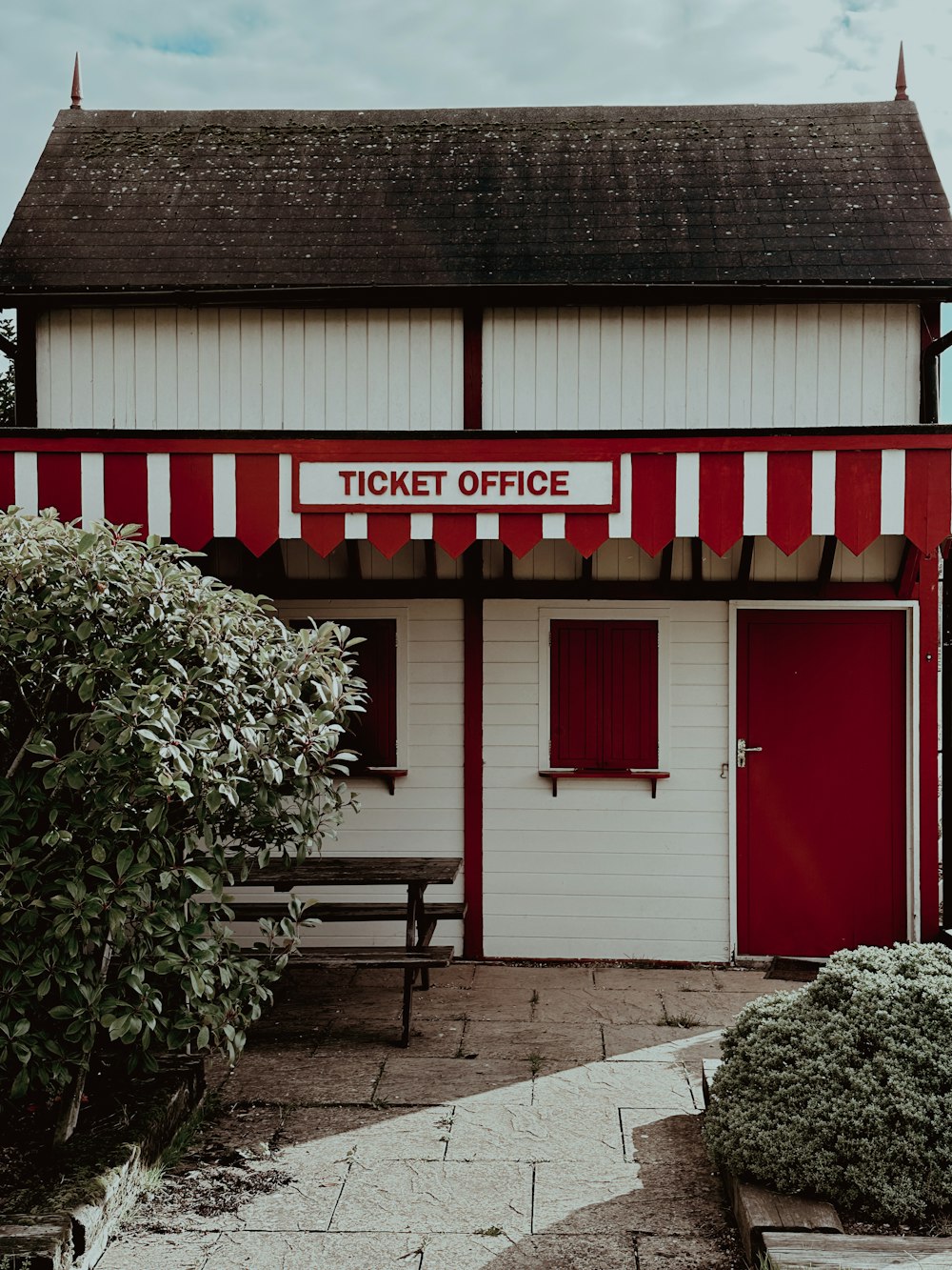 a red and white building with a ticket office