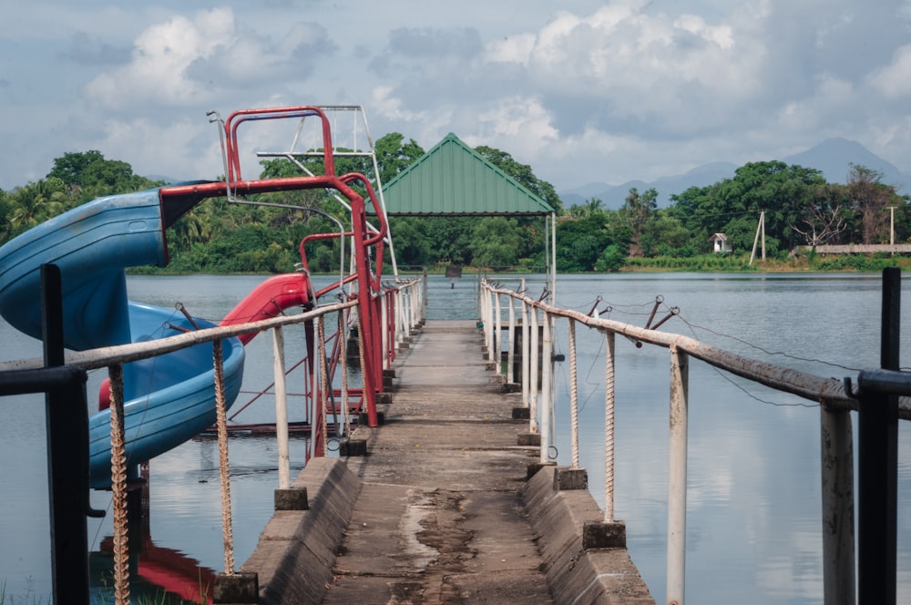 a blue water slide sitting on top of a wooden pier