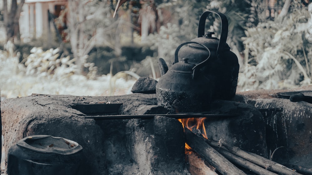 a kettle sitting on top of a fire pit