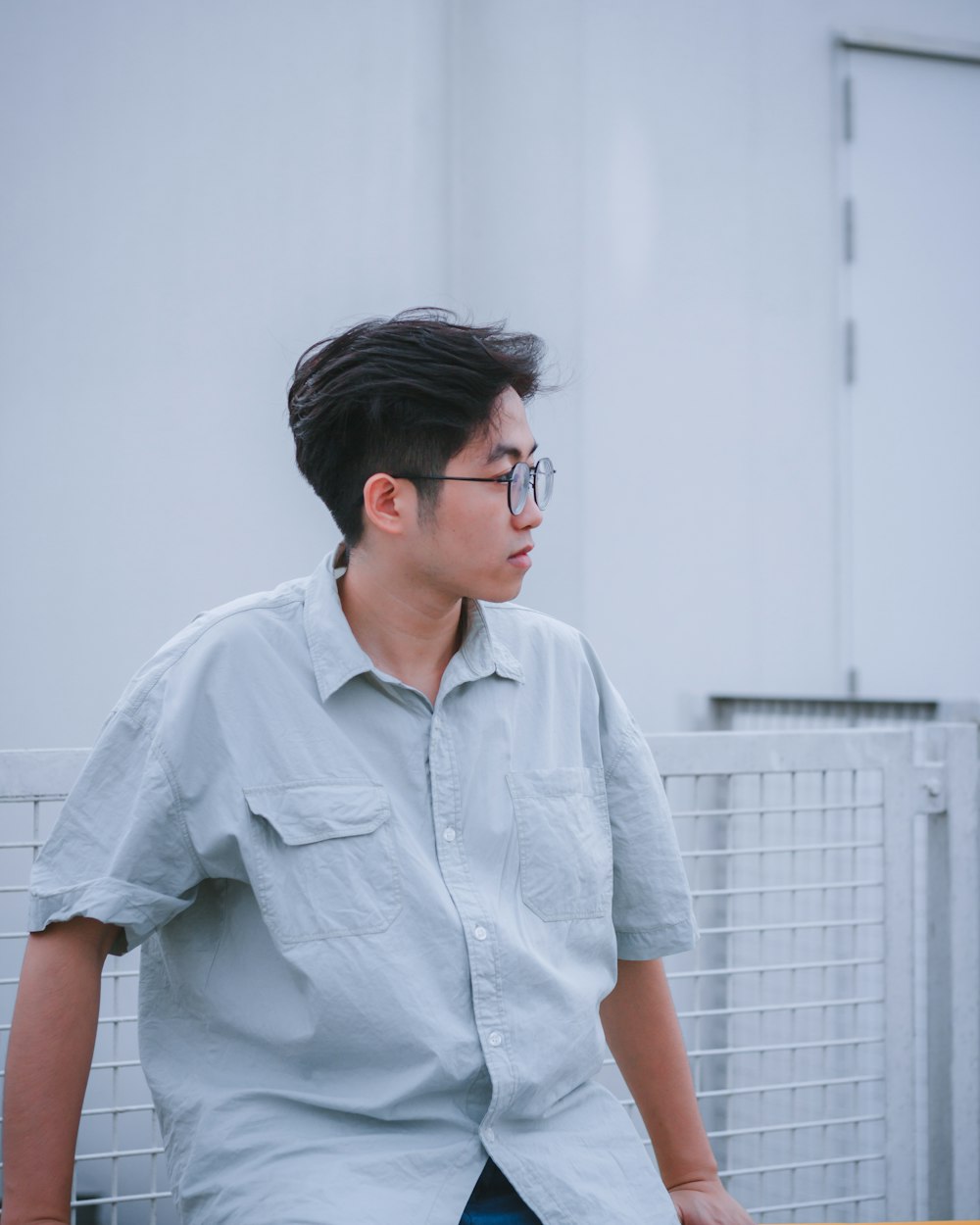 a man with glasses sitting on a bench