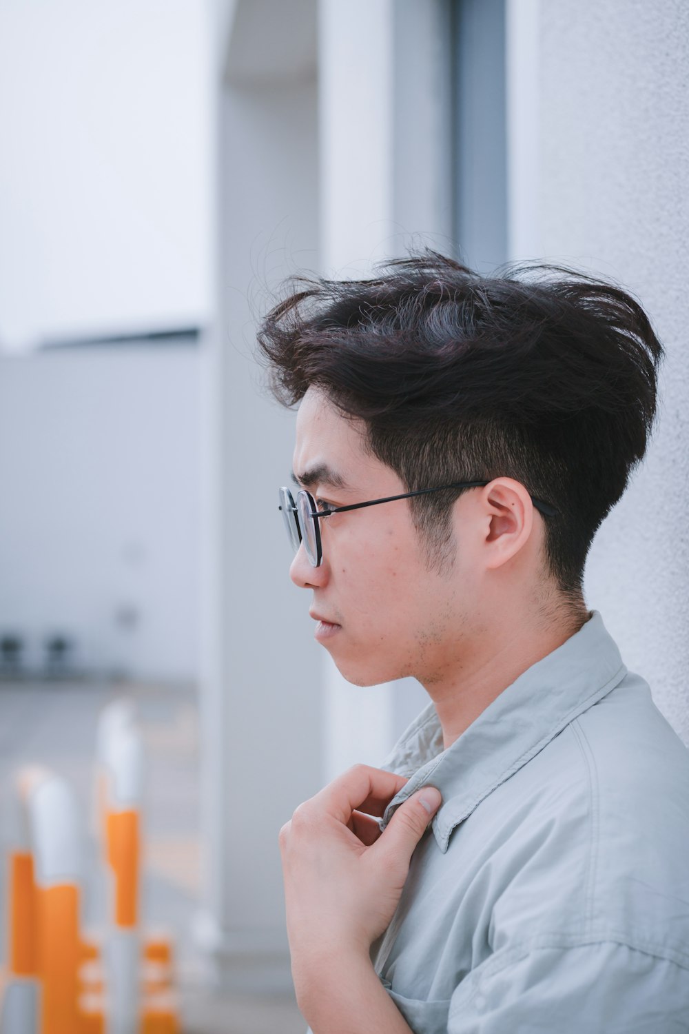 a man with glasses is adjusting his tie