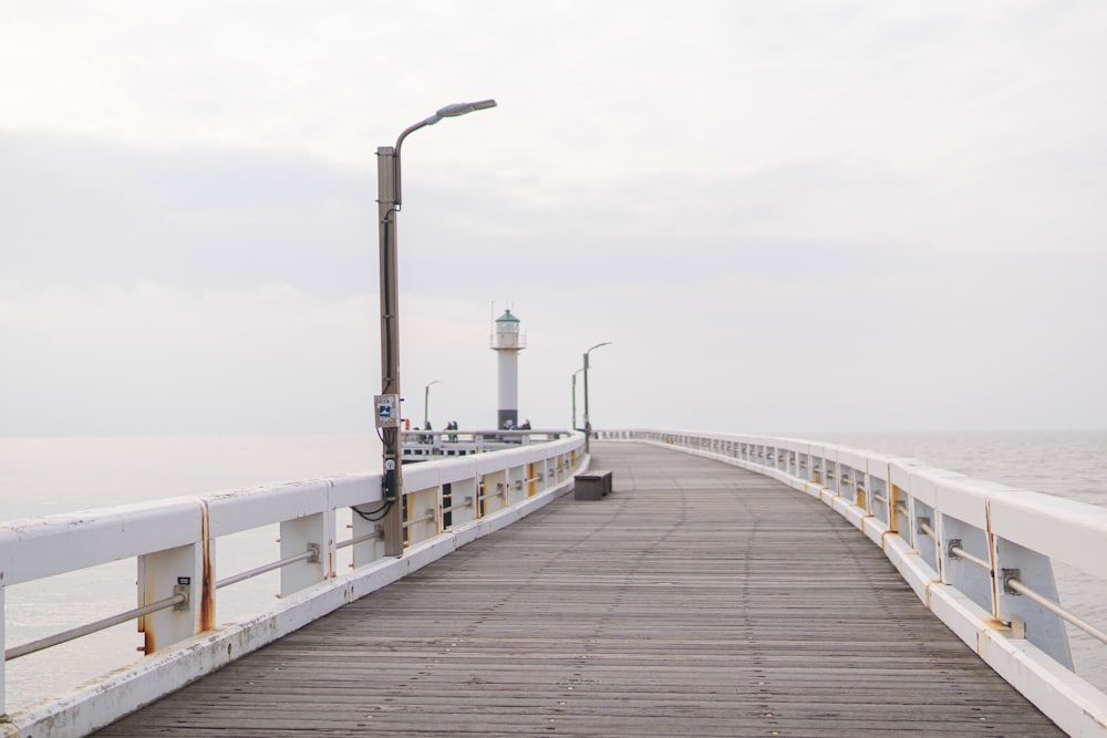 a pier with a light house in the distance