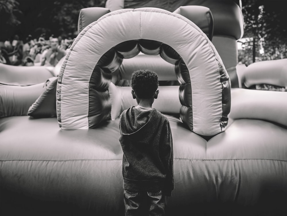 a young boy standing in front of an inflatable arch