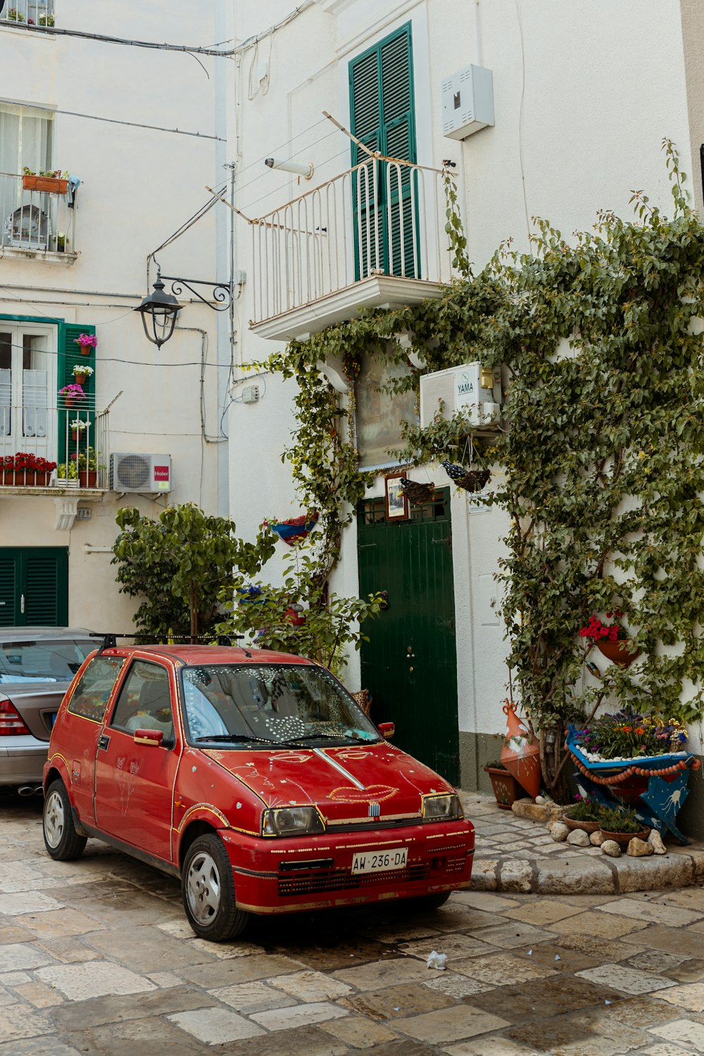 a red car parked in front of a white building