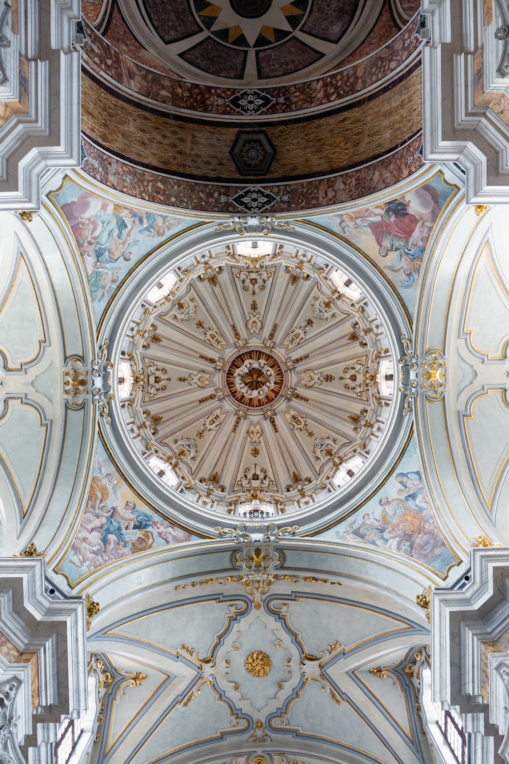 the ceiling of a large building with a clock on it