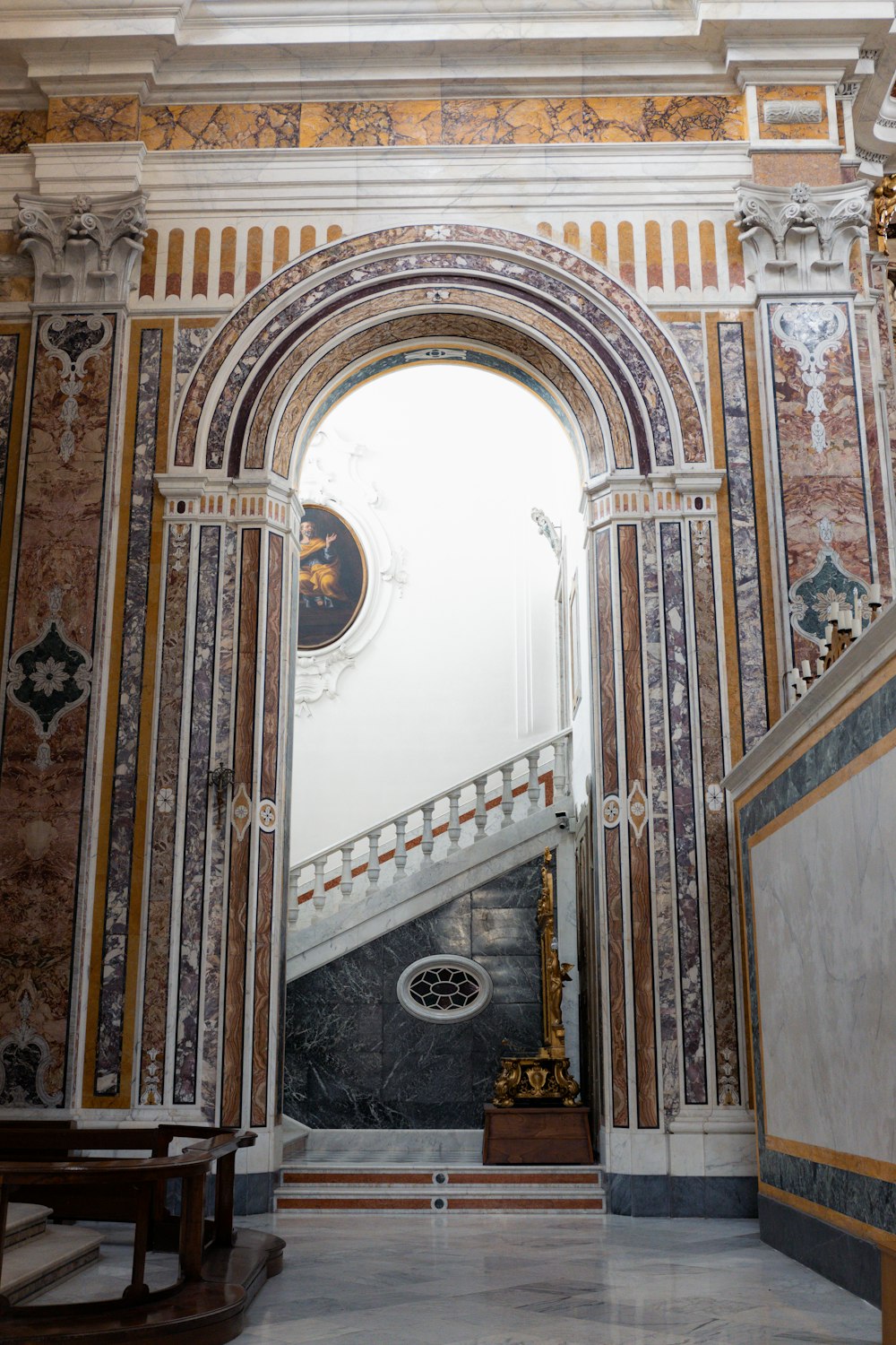 an ornate archway with a statue in the middle of it