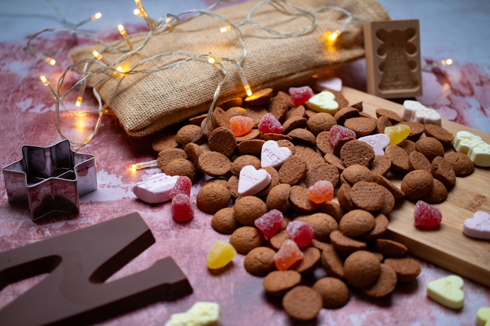 a wooden cutting board topped with lots of heart shaped treats