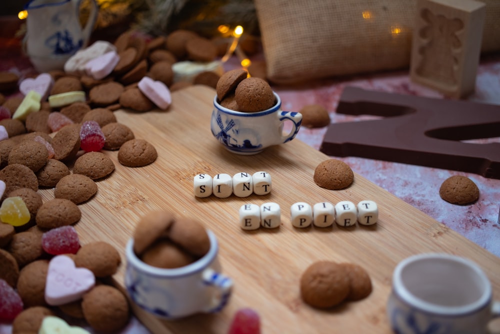 a wooden cutting board topped with lots of cookies