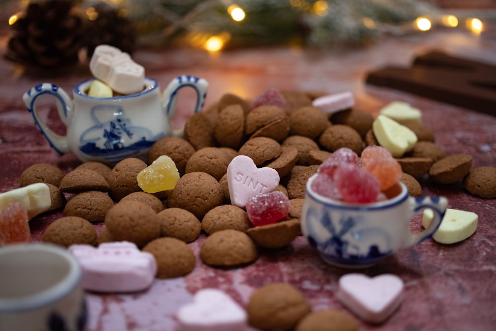 a table topped with cups filled with different types of candies