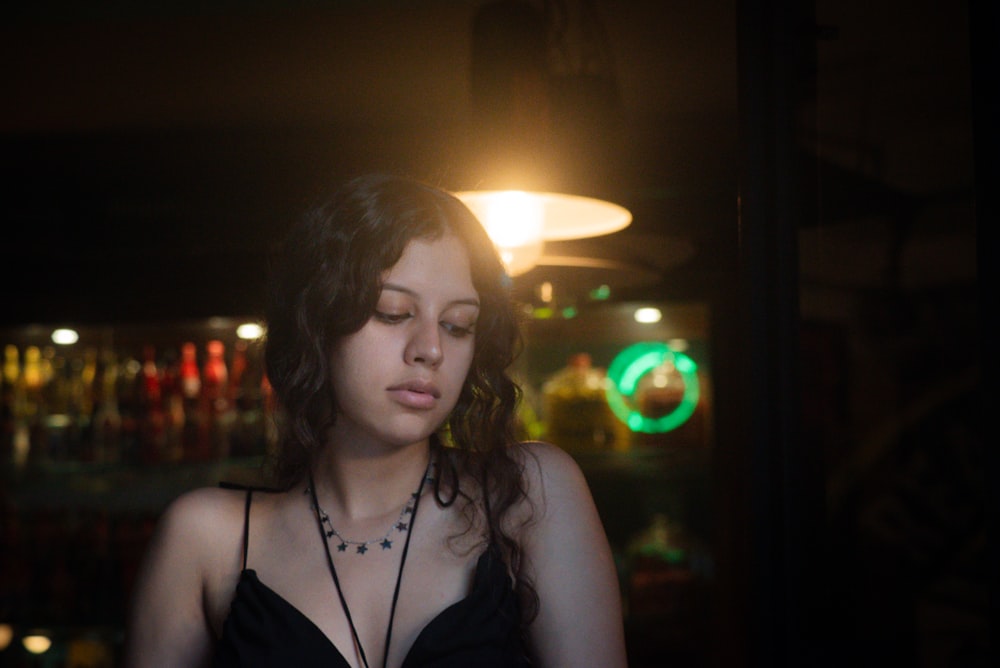 a woman in a dark room looking at her cell phone