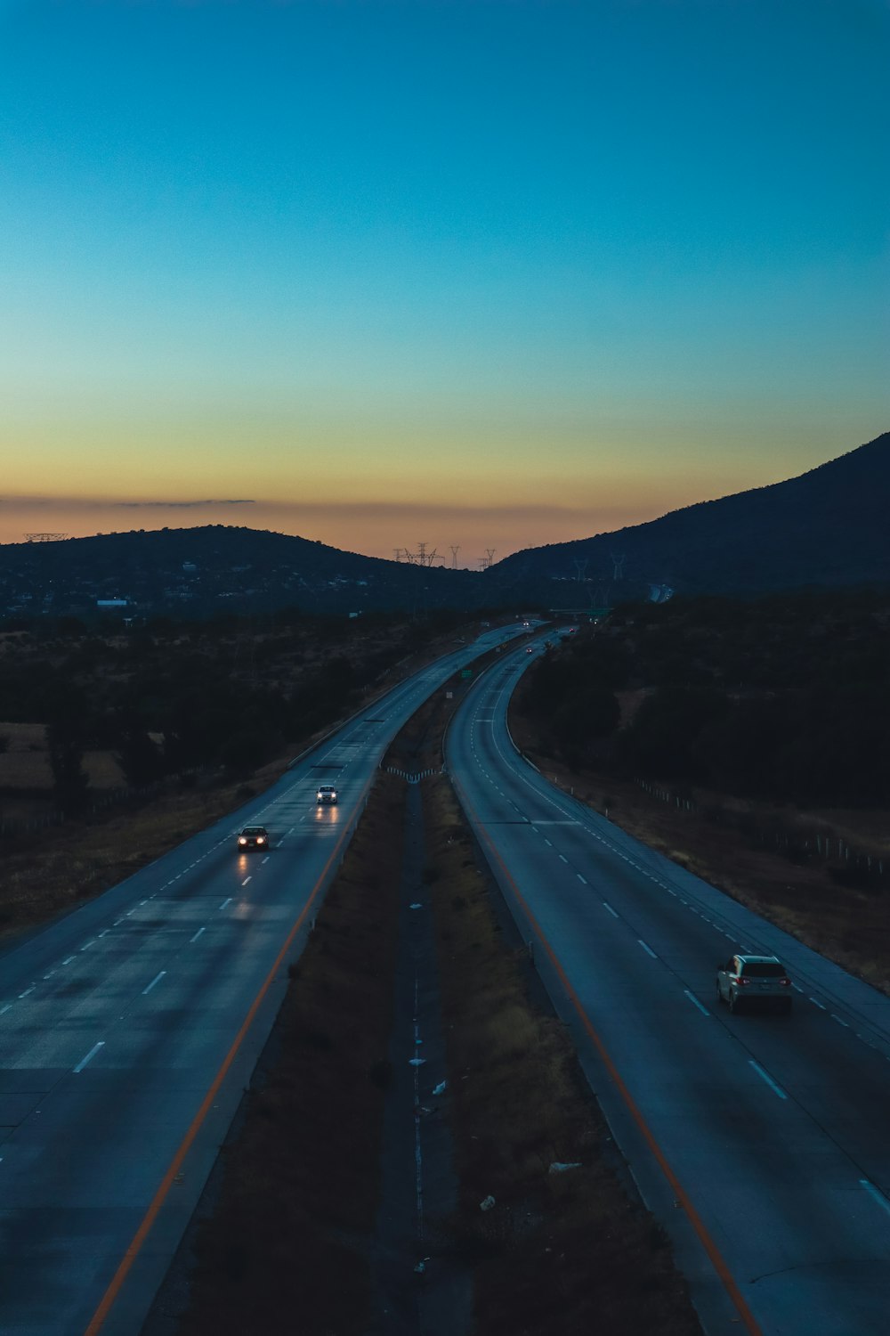 a highway with cars driving down it at dusk