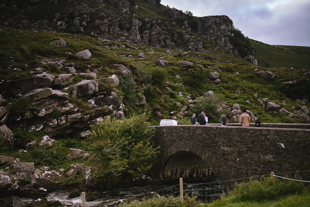 a group of people standing on a bridge over a river