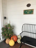A charming entryway featuring a mix of colorful gourds and squash arranged artfully around a welcoming wooden bench