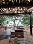 A cozy outdoor seating area surrounding modern containers with beach access in the background.