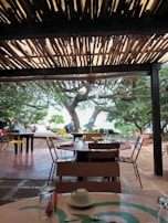 A cozy outdoor dining setup with ocean views and tropical decor.