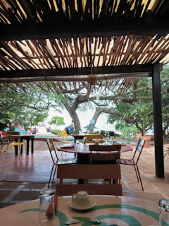 A cozy outdoor dining setup with ocean views and tropical decor.