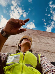 A construction worker wearing a hard hat, looking concerned after a workplace accident.