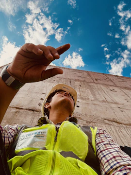A construction worker wearing a hard hat, looking concerned after a workplace accident.