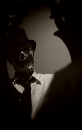 A sleek black and gold cinematic frame with a mysterious masked figure in soft focus.