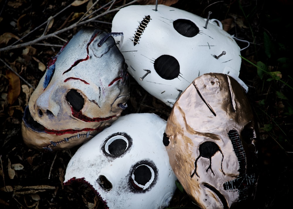 a group of three painted masks laying on the ground