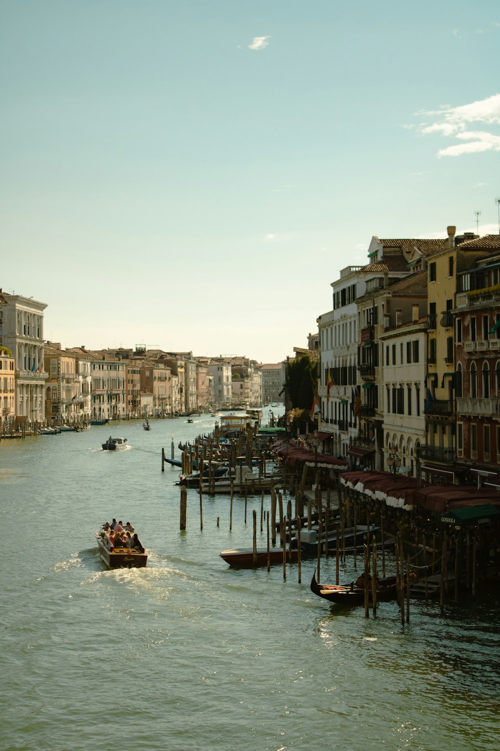 a boat traveling down a river next to tall buildings