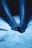 A close-up of bare feet resting on a soft, textured surface lit with a blue tone, creating a tranquil and serene atmosphere.