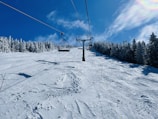 Ski lift ascending above untouched snow under a winter sky