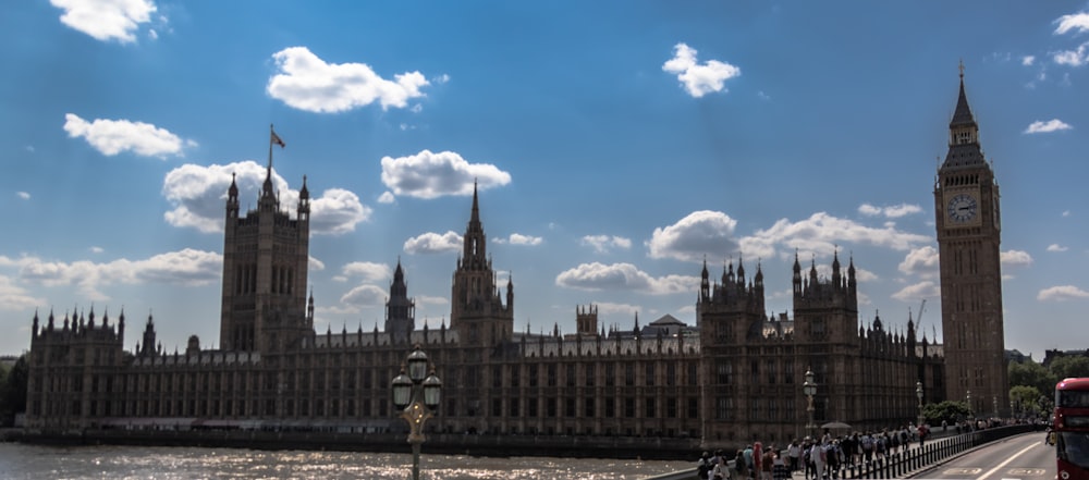 a large building with a clock tower next to a river