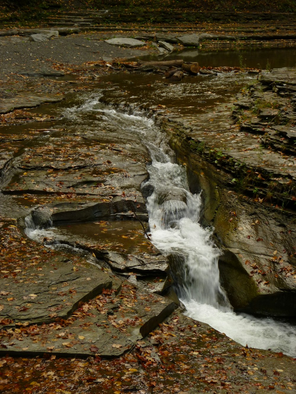 a small stream of water running between rocks