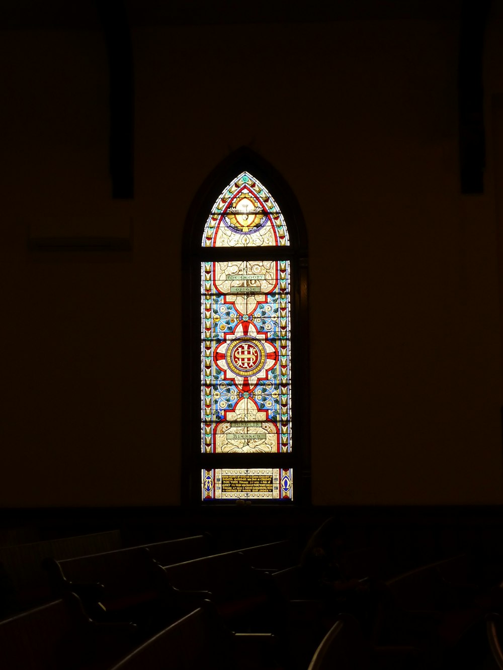 a stained glass window in a church with pews
