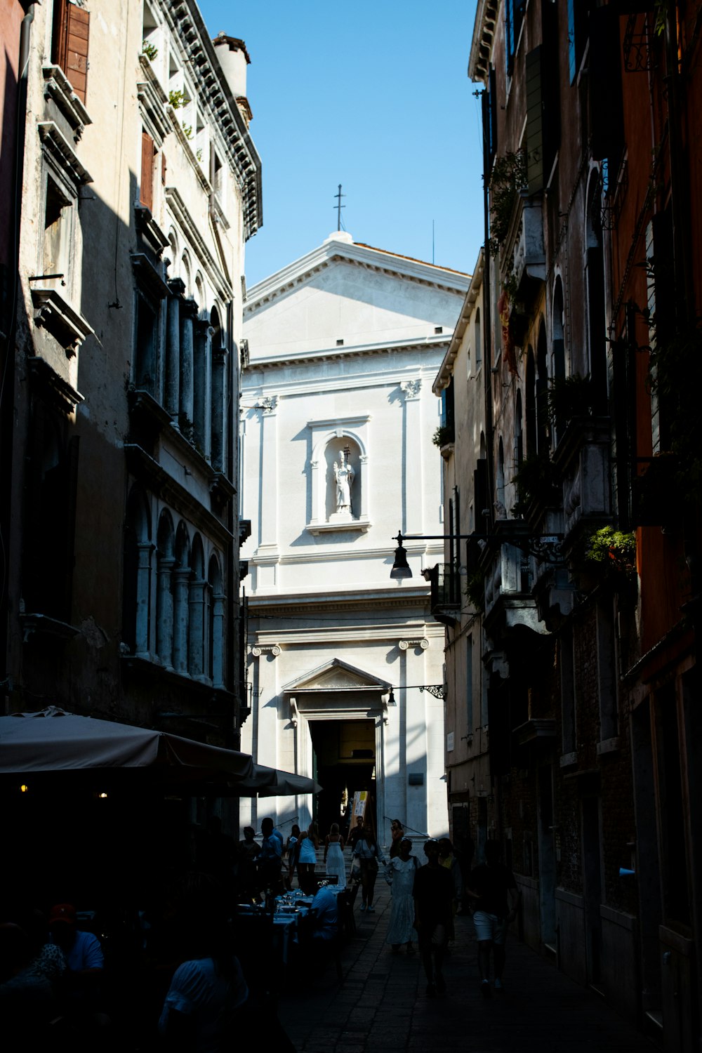 a narrow city street with a church in the background