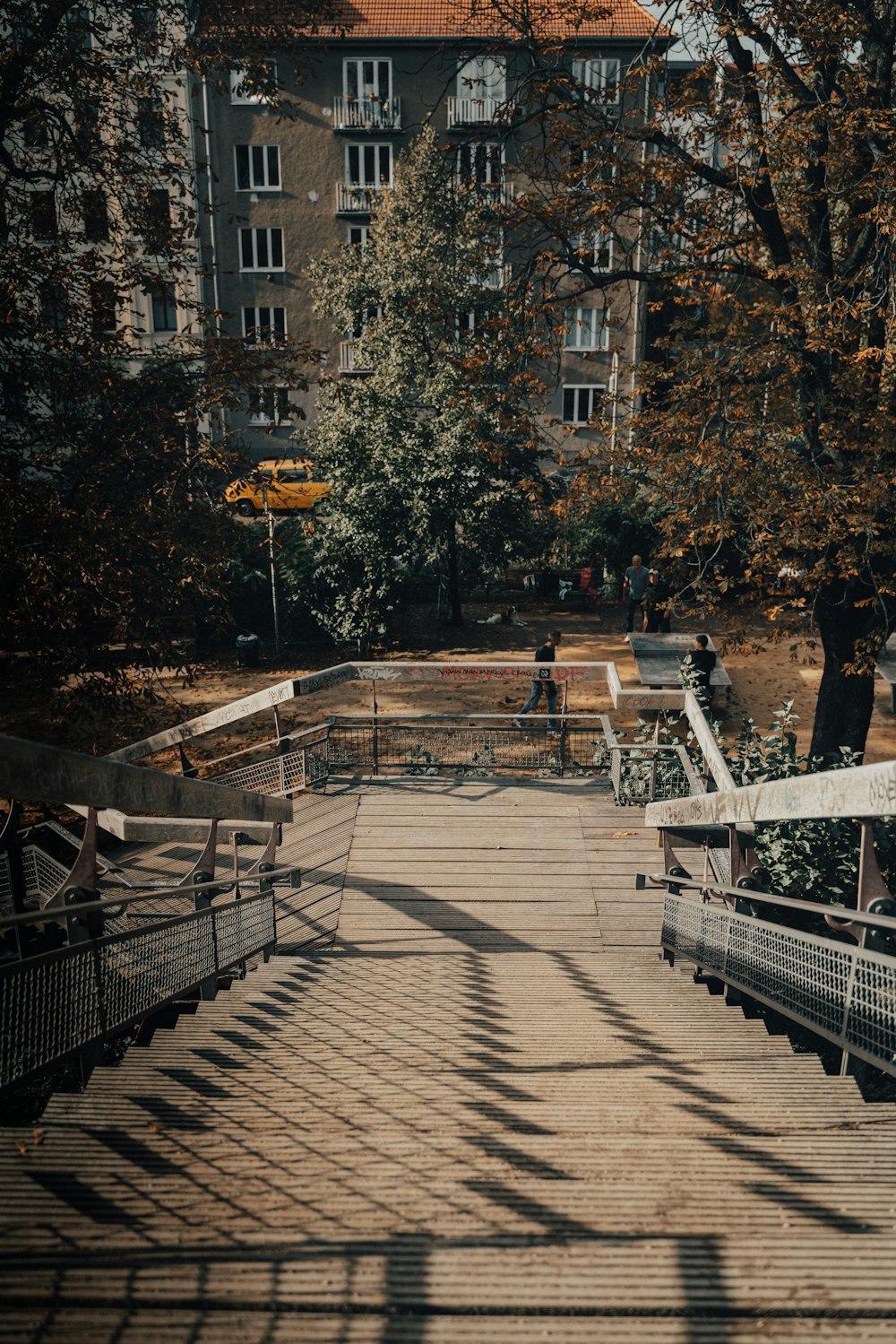 a person walking down a wooden walkway in a park