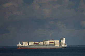 A cargo ship loaded with containers sailing on a calm sea, representing international export and import.
