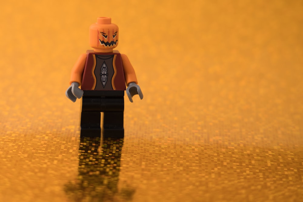 a lego figure is standing on a shiny surface