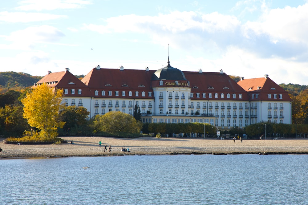 a large white building sitting next to a body of water