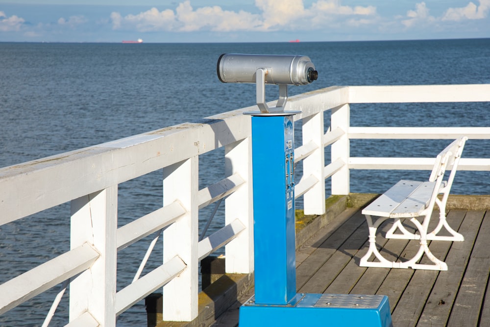 un banc et un télescope sur une jetée surplombant l’océan