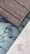 A section of wooden deck planks next to an area featuring marble-like tiles and a light-colored stone surface. The textures of the materials are distinct, with the wooden planks showing a rough grain, while the tiles have smooth, swirling dark patterns on a white background.