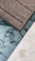 A section of wooden deck planks next to an area featuring marble-like tiles and a light-colored stone surface. The textures of the materials are distinct, with the wooden planks showing a rough grain, while the tiles have smooth, swirling dark patterns on a white background.