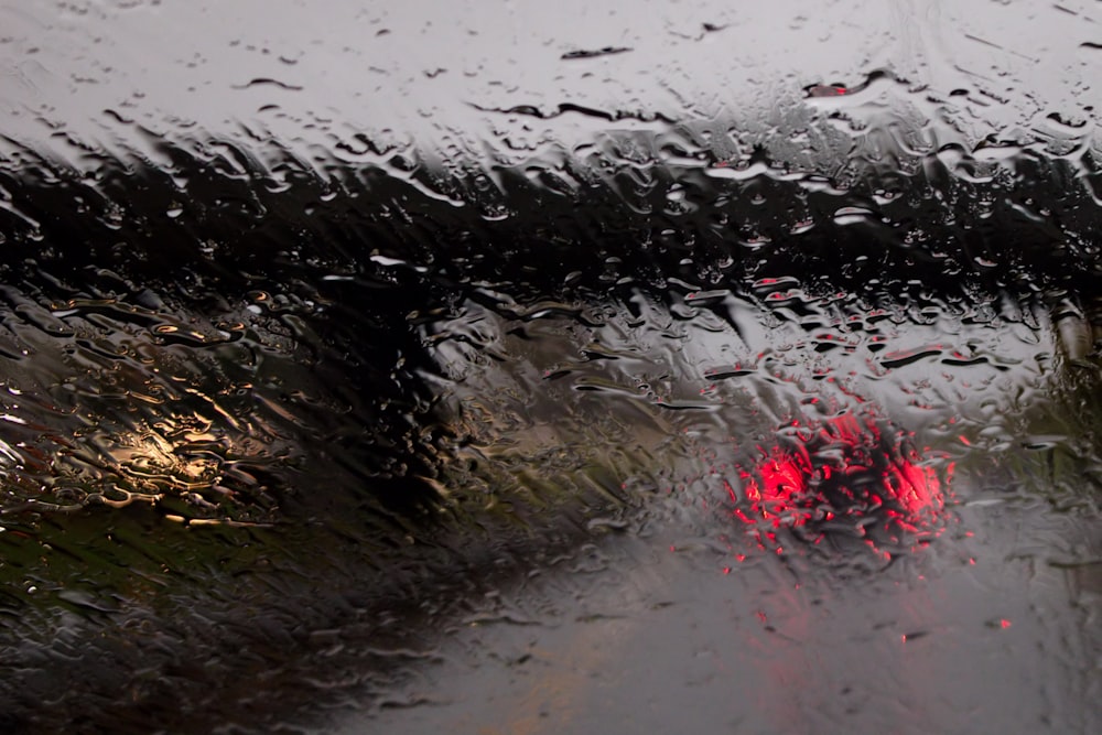 a view of a street through a rain covered windshield