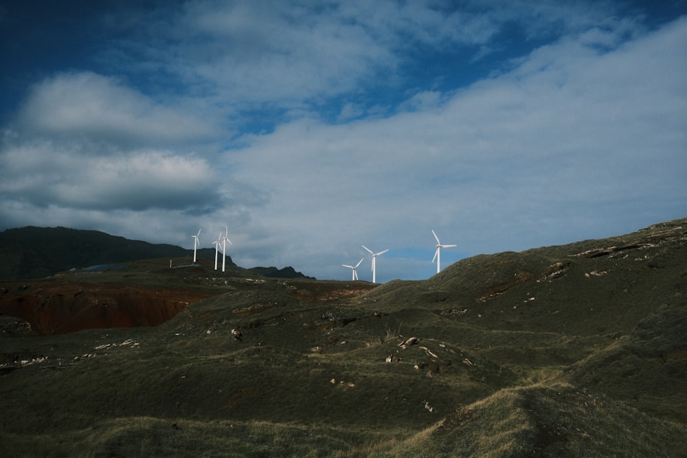 a group of wind turbines on a hill