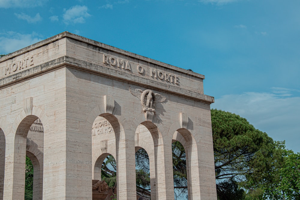 a stone building with arches and a clock on top of it