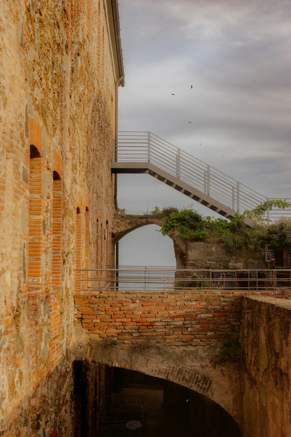 an old brick building with a bridge going over it