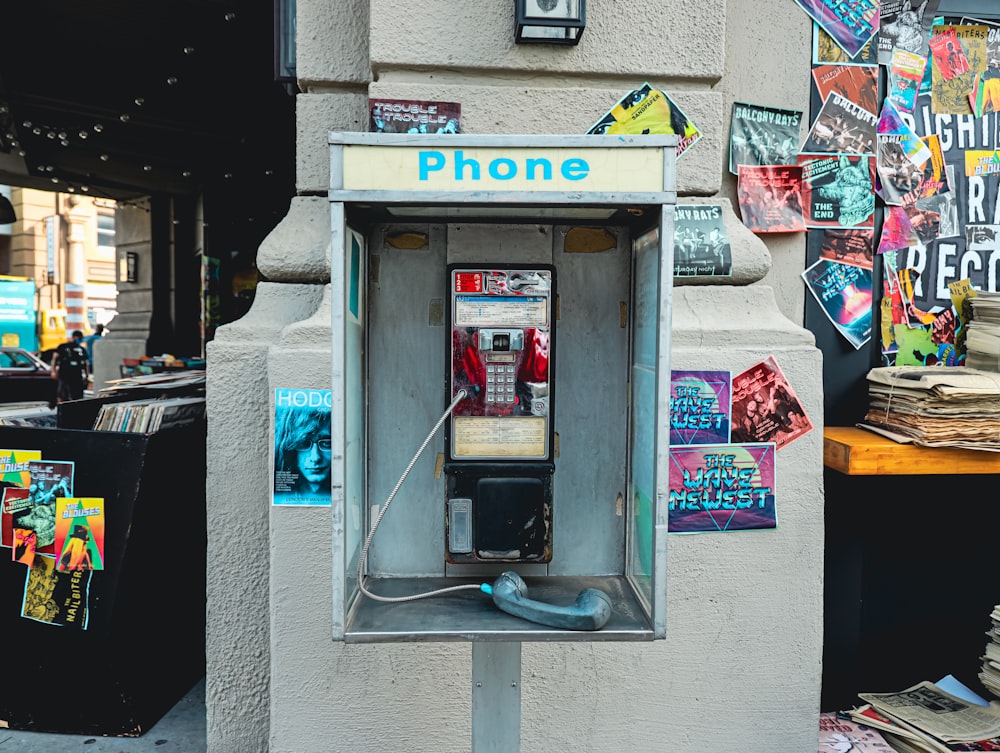 une cabine téléphonique avec beaucoup d’autocollants dessus