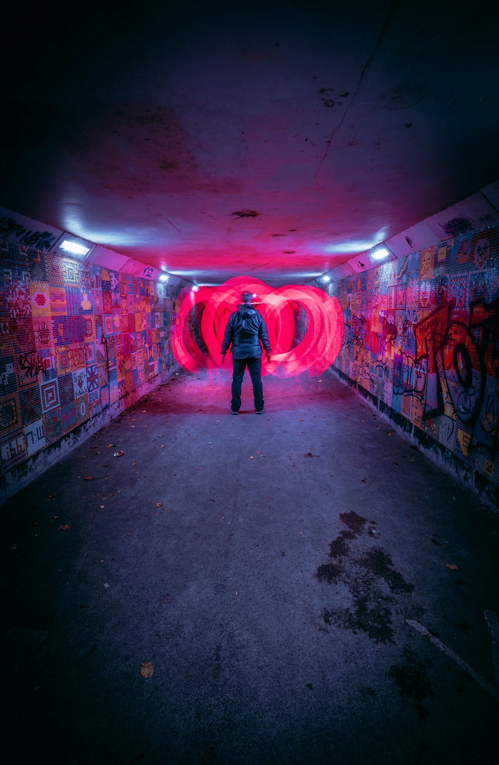 una persona parada en un túnel con grafitis en las paredes