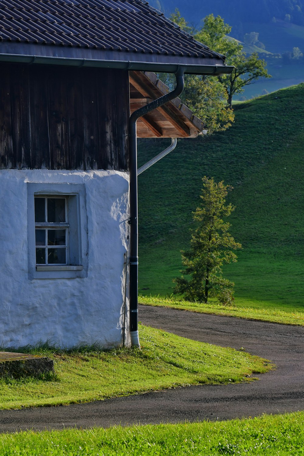 a small white building with a black roof